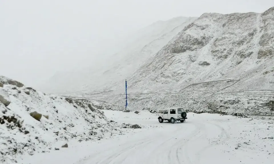 Vehicle on a snow-covered mountain road in Ladakh