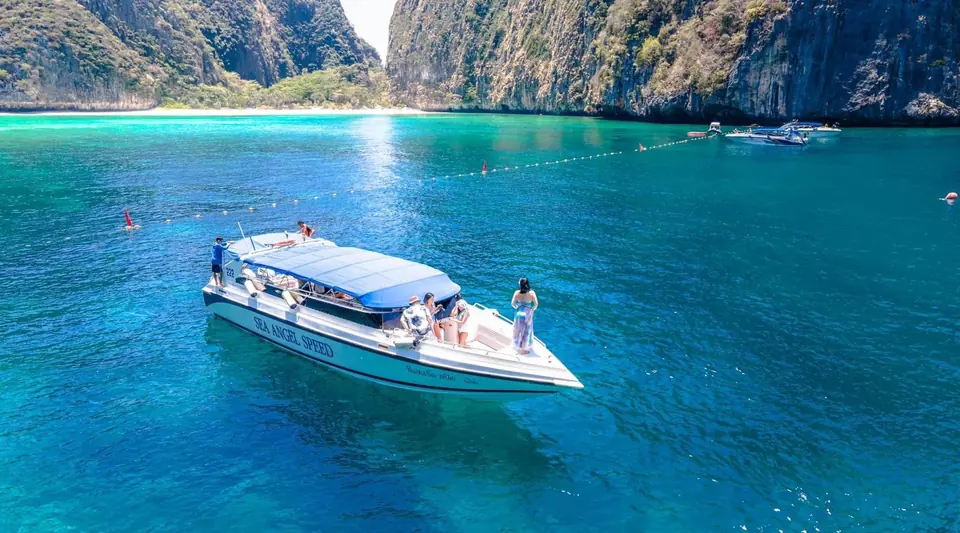 Speedboat in turquoise water between Phi Phi cliffs
