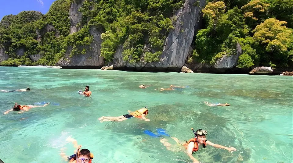 Snorkellers in clear water off a limestone island